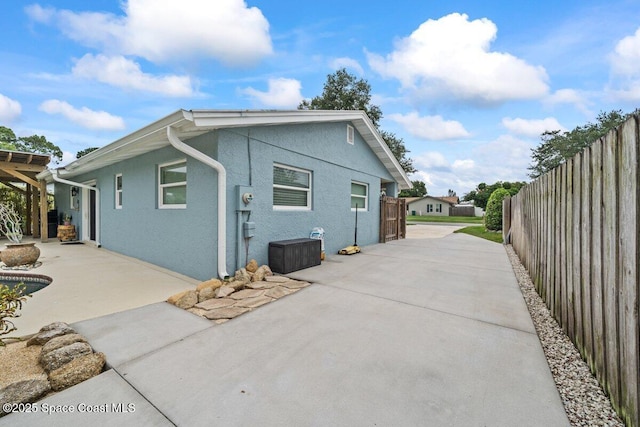 609 Tallwood Cir, Melbourne, FL 32904 - view of side of property featuring a patio and stucco siding