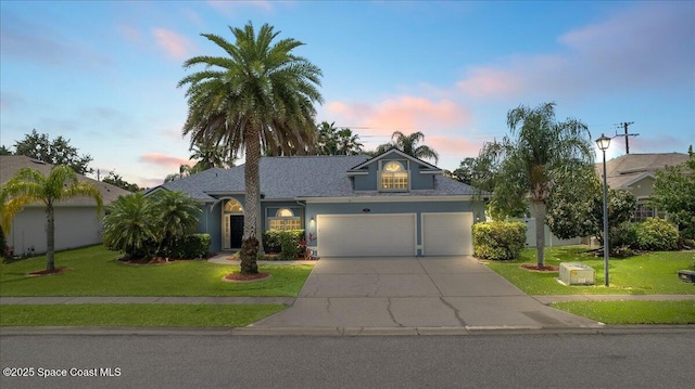 2465 Tuscarora Ct, Melbourne, FL 32904 - view of front of home featuring concrete driveway, a lawn, stucco siding, an attached garage, and roof with shingles