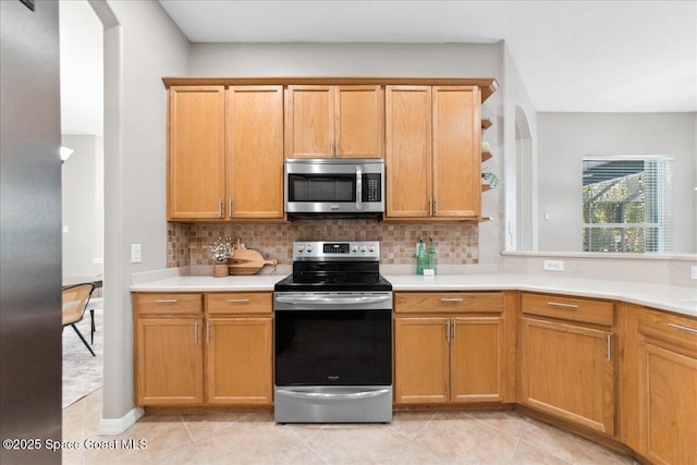 2465 Tuscarora Ct, Melbourne, FL 32904 - kitchen featuring stainless steel appliances, decorative backsplash, light countertops, and light tile patterned floors