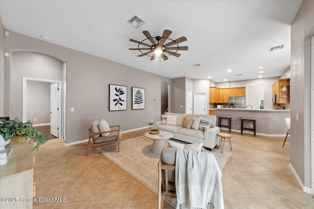 2465 Tuscarora Ct, Melbourne, FL 32904 - living room with arched walkways, ceiling fan, light tile patterned floors, and baseboards