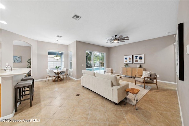 2465 Tuscarora Ct, Melbourne, FL 32904 - living area with light tile patterned floors, a ceiling fan, arched walkways, baseboards, and recessed lighting