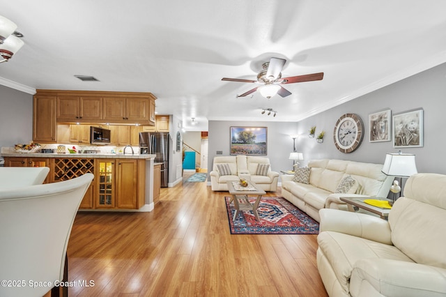 109 Plover Ln Unit 4-35, Rockledge, FL 32955 - living room featuring crown molding, a ceiling fan, light wood-type flooring, and baseboards