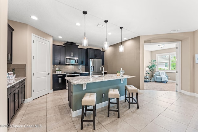 3387 Caviston Way, Melbourne, FL 32940 - kitchen featuring stainless steel appliances, a breakfast bar, tasteful backsplash, recessed lighting, and a center island with sink