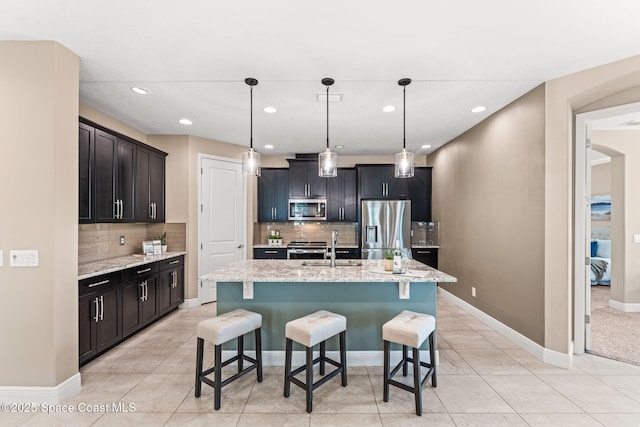 3387 Caviston Way, Melbourne, FL 32940 - kitchen with appliances with stainless steel finishes, a sink, a breakfast bar area, decorative backsplash, and light stone countertops