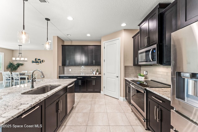 3387 Caviston Way, Melbourne, FL 32940 - kitchen featuring appliances with stainless steel finishes, a sink, decorative light fixtures, light stone counters, and tasteful backsplash