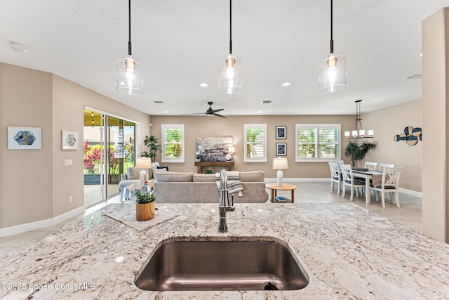 3387 Caviston Way, Melbourne, FL 32940 - kitchen featuring a sink, light stone counters, baseboards, healthy amount of natural light, and recessed lighting