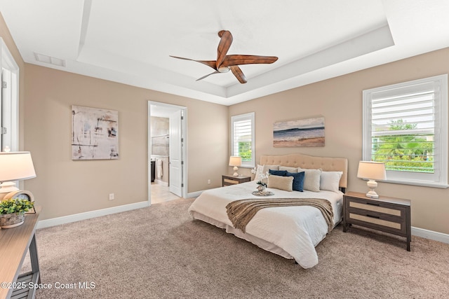 3387 Caviston Way, Melbourne, FL 32940 - bedroom with a raised ceiling, light colored carpet, baseboards, and connected bathroom