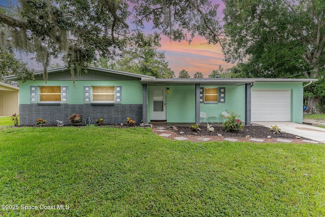 2109 Ivy Dr, Cocoa, FL 32922 - view of front of home with a garage, concrete block siding, driveway, and a front lawn