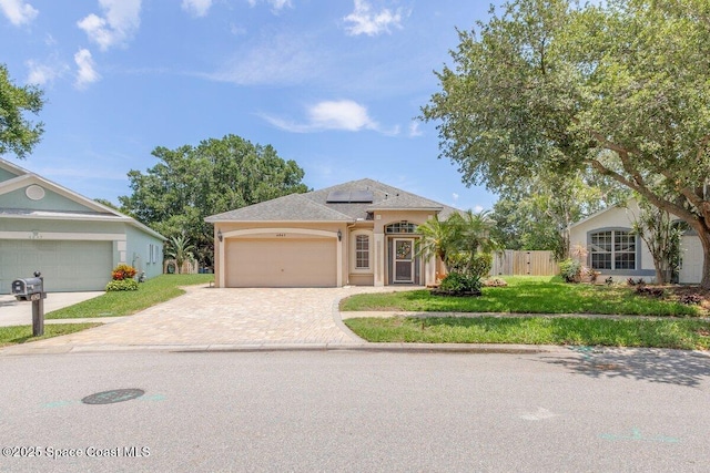 4843 Erin Ln, Melbourne, FL 32940 - ranch-style home featuring driveway, solar panels, an attached garage, and stucco siding