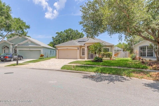 4843 Erin Ln, Melbourne, FL 32940 - ranch-style house with driveway, an attached garage, roof mounted solar panels, and stucco siding