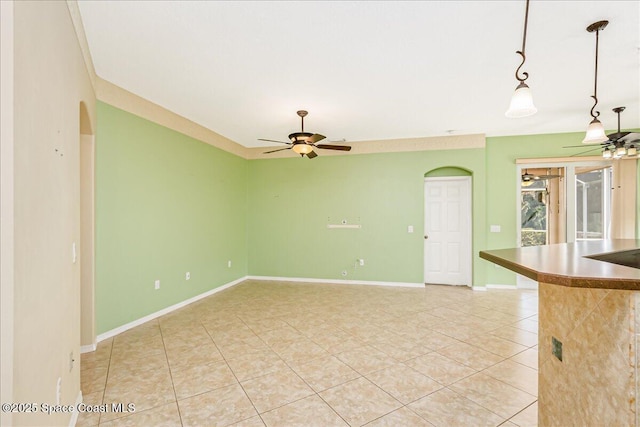 4843 Erin Ln, Melbourne, FL 32940 - unfurnished room featuring light tile patterned floors, a ceiling fan, baseboards, and arched walkways