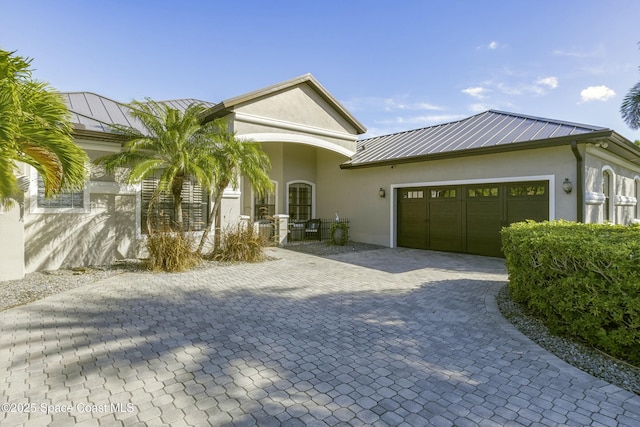 5145 Limousin Ct, Rockledge, FL 32955 - ranch-style house featuring a standing seam roof, stucco siding, a garage, metal roof, and decorative driveway