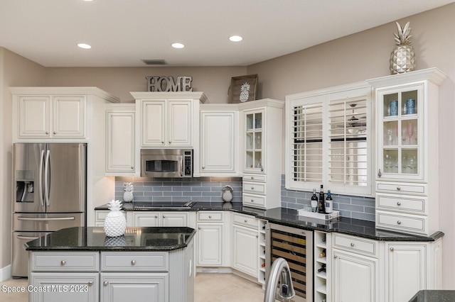 5145 Limousin Ct, Rockledge, FL 32955 - kitchen with appliances with stainless steel finishes, backsplash, wine cooler, white cabinets, and recessed lighting