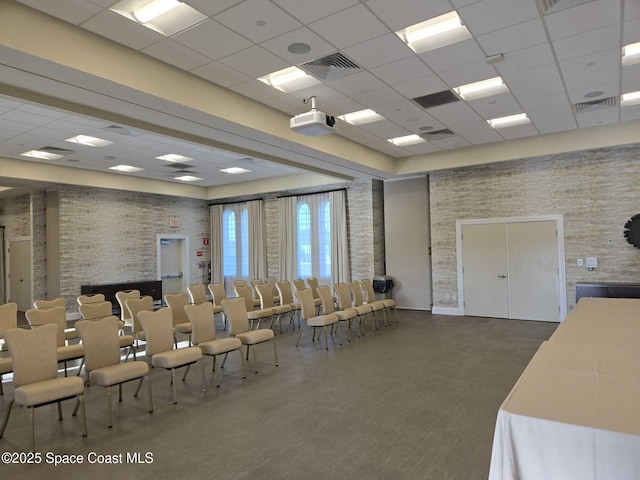 7690 Kerrington Dr, Melbourne, FL 32940 - miscellaneous room with a paneled ceiling, brick wall, and carpet floors