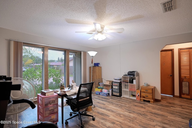 1387 Gleneagles Ct, Rockledge, FL 32955 - office area with wood finished floors, ceiling fan, arched walkways, and a textured ceiling