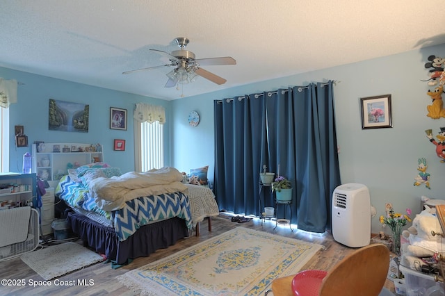 1387 Gleneagles Ct, Rockledge, FL 32955 - bedroom with wood finished floors, ceiling fan, and a textured ceiling