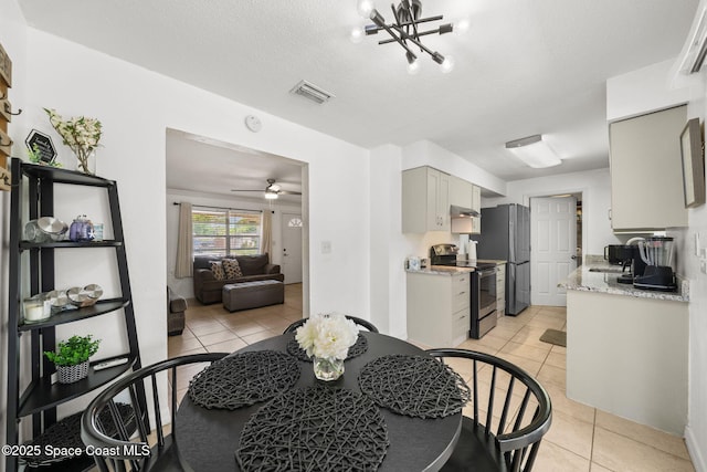 1941 Dawn Dr, Melbourne, FL 32935 - dining room with light tile patterned floors, a ceiling fan, and a chandelier