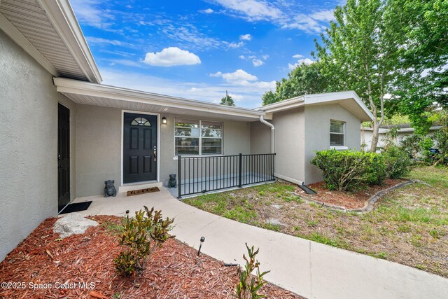 1941 Dawn Dr, Melbourne, FL 32935 - doorway to property featuring stucco siding and covered porch