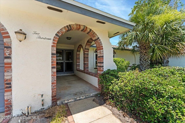 213 Harbour Dr W, Indian Harbour Beach, FL 32937 - view of exterior entry featuring stucco siding and brick siding