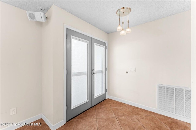 213 Harbour Dr W, Indian Harbour Beach, FL 32937 - spare room featuring french doors, baseboards, a textured ceiling, and light tile patterned flooring