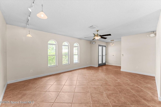 213 Harbour Dr W, Indian Harbour Beach, FL 32937 - spare room featuring ceiling fan, a textured ceiling, rail lighting, light tile patterned flooring, and baseboards