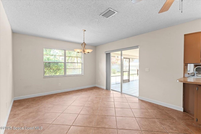 213 Harbour Dr W, Indian Harbour Beach, FL 32937 - unfurnished dining area featuring a chandelier, a textured ceiling, ceiling fan, light tile patterned floors, and a sink
