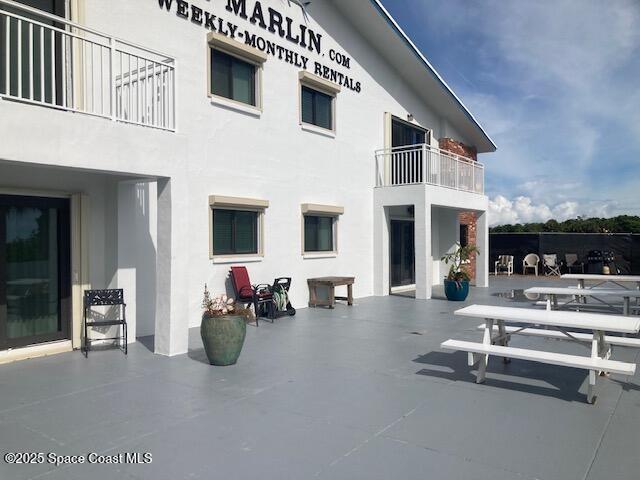 22 Tulip Ave Unit 318, Cocoa Beach, FL 32931 - back of property featuring stucco siding and a patio