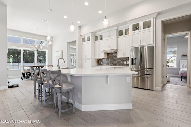 1025 Aranceto Cir, Merritt Island, FL 32952 - kitchen featuring stainless steel fridge with ice dispenser, under cabinet range hood, light countertops, a spacious island, and recessed lighting