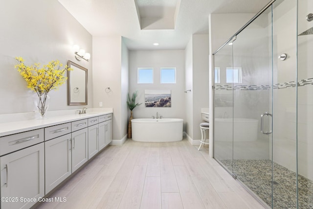 1025 Aranceto Cir, Merritt Island, FL 32952 - full bathroom with vanity, a stall shower, a freestanding bath, and wood finished floors