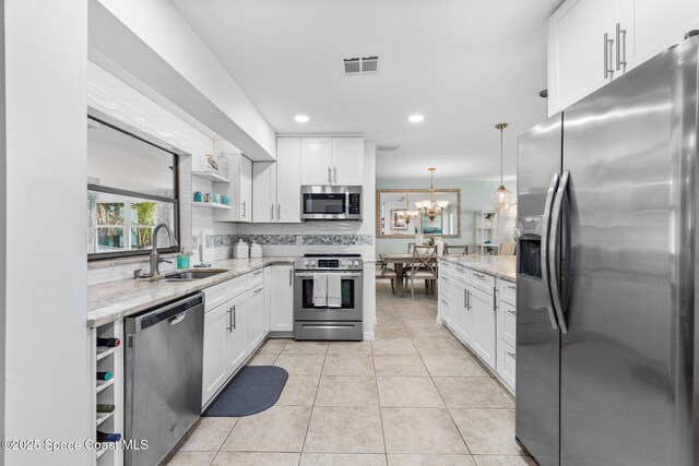 715 Atlantic Dr, Satellite Beach, FL 32937 - kitchen featuring appliances with stainless steel finishes, open shelves, white cabinetry, light stone counters, and recessed lighting