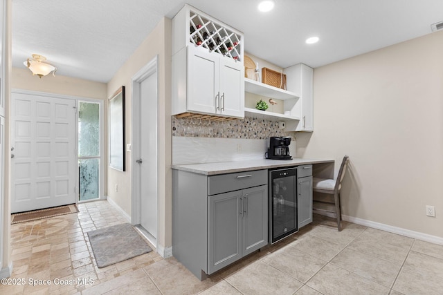 715 Atlantic Dr, Satellite Beach, FL 32937 - kitchen featuring wine cooler, gray cabinets, open shelves, backsplash, and light countertops