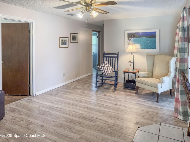 1395 Angler St, Merritt Island, FL 32952 - living area featuring light wood finished floors, a ceiling fan, a textured ceiling, and baseboards