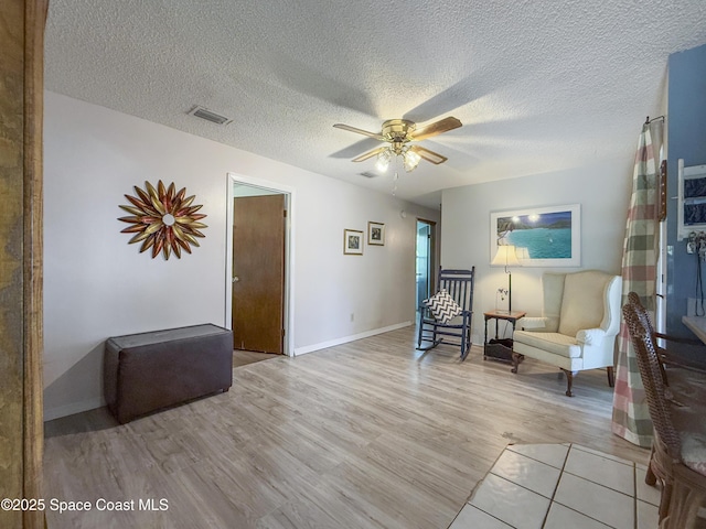 1395 Angler St, Merritt Island, FL 32952 - living area featuring a ceiling fan, light wood-style flooring, baseboards, and a textured ceiling