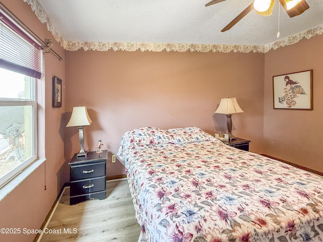 1395 Angler St, Merritt Island, FL 32952 - bedroom featuring light wood-style flooring, baseboards, a textured ceiling, and ceiling fan