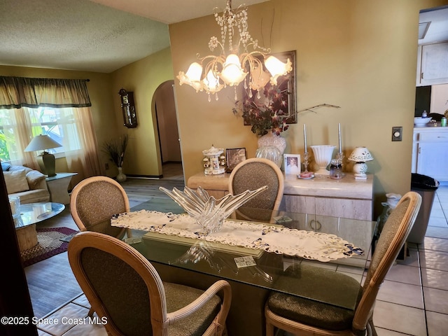 1395 Angler St, Merritt Island, FL 32952 - dining space with arched walkways, a chandelier, a textured ceiling, and wood finished floors