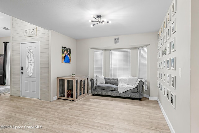 4236 Pondapple Dr, Titusville, FL 32796 - living area featuring light wood-style flooring, a chandelier, and baseboards