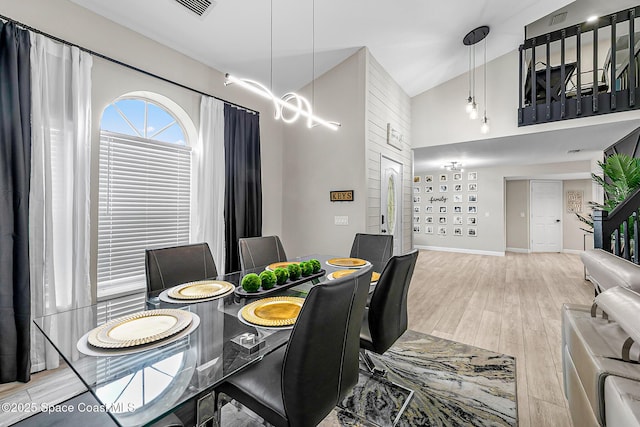 4236 Pondapple Dr, Titusville, FL 32796 - dining room with light wood-type flooring, a towering ceiling, and baseboards