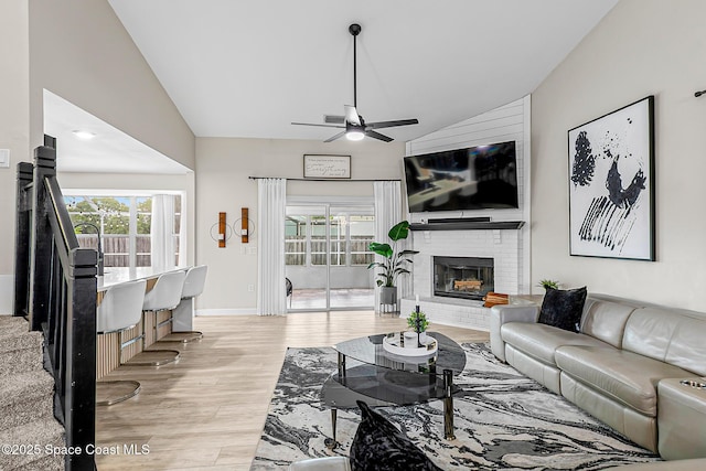 4236 Pondapple Dr, Titusville, FL 32796 - living area with vaulted ceiling, ceiling fan, light wood-type flooring, a brick fireplace, and baseboards