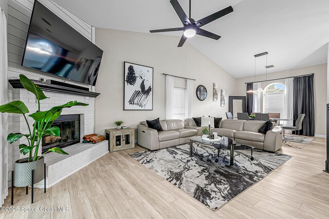 4236 Pondapple Dr, Titusville, FL 32796 - living room with ceiling fan, wood finished floors, a brick fireplace, and high vaulted ceiling