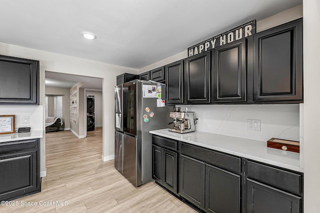 4236 Pondapple Dr, Titusville, FL 32796 - kitchen featuring stainless steel fridge with ice dispenser, light countertops, light wood-type flooring, dark cabinets, and baseboards