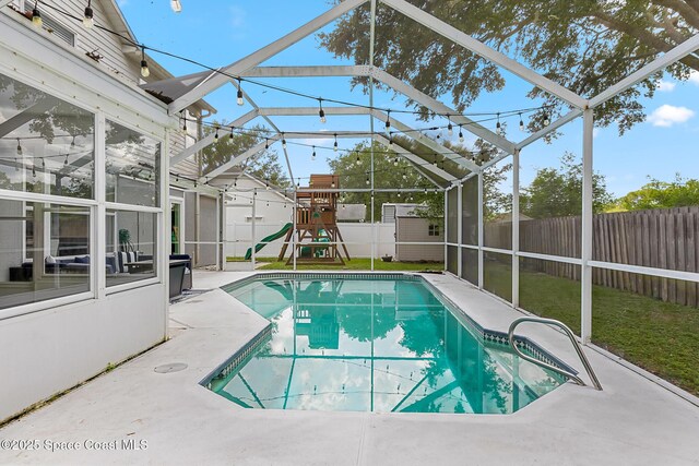 4236 Pondapple Dr, Titusville, FL 32796 - view of swimming pool with a patio area, glass enclosure, and a playground