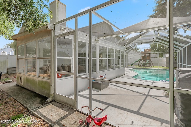4236 Pondapple Dr, Titusville, FL 32796 - view of swimming pool featuring a sunroom, a patio, a fenced backyard, and a playground