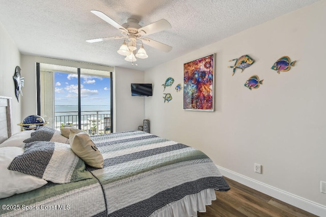 3221 S Atlantic Ave Unit 703, Cocoa Beach, FL 32931 - bedroom featuring access to outside, wood finished floors, baseboards, a textured ceiling, and ceiling fan