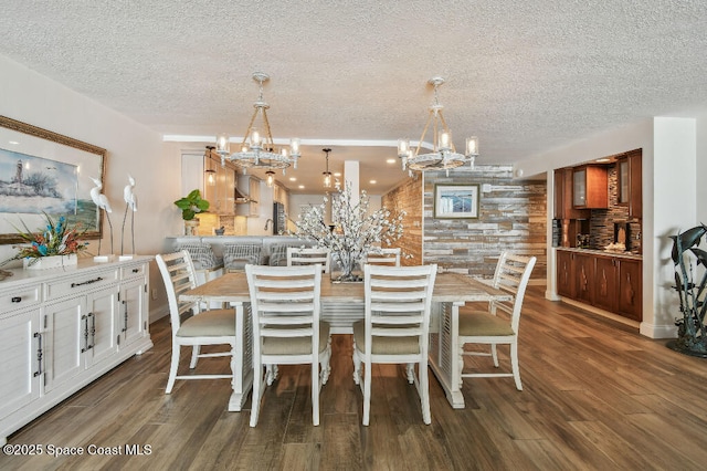 3221 S Atlantic Ave Unit 703, Cocoa Beach, FL 32931 - dining area featuring a textured ceiling, a chandelier, and wood finished floors