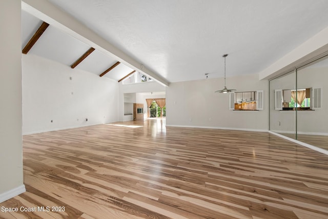 105 Osprey Ct, Melbourne, FL 32940 - unfurnished living room featuring light wood-style flooring, beamed ceiling, baseboards, and high vaulted ceiling