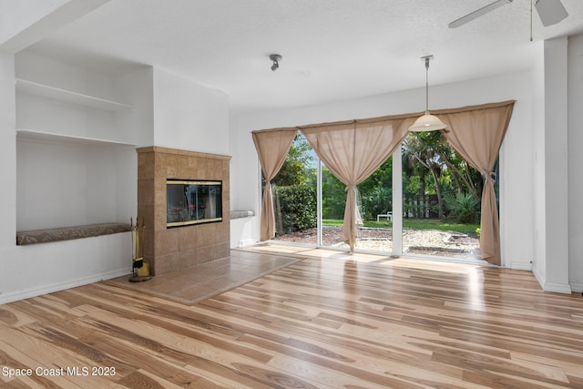 105 Osprey Ct, Melbourne, FL 32940 - unfurnished living room with light wood finished floors, ceiling fan, a fireplace, and baseboards