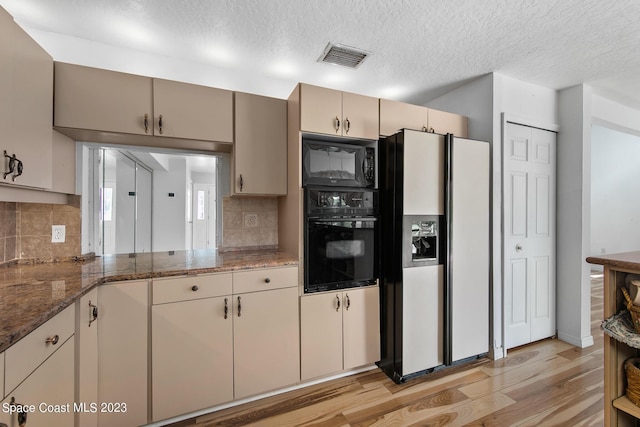 105 Osprey Ct, Melbourne, FL 32940 - kitchen with black appliances, light wood finished floors, backsplash, a textured ceiling, and dark stone counters