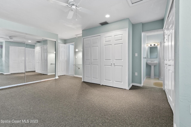 105 Osprey Ct, Melbourne, FL 32940 - unfurnished bedroom with dark carpet, two closets, a sink, baseboards, and recessed lighting