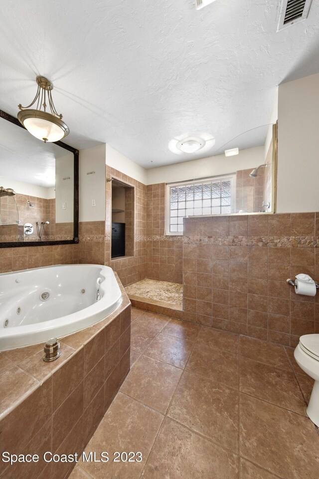 105 Osprey Ct, Melbourne, FL 32940 - full bath featuring tile walls, walk in shower, tile patterned floors, a whirlpool tub, and toilet