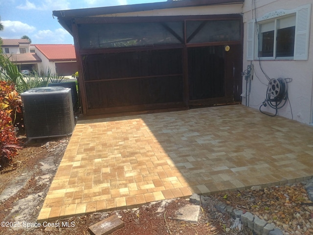 105 Osprey Ct, Melbourne, FL 32940 - view of patio with central air condition unit, a garage, and a sunroom